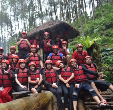 Foto karyawan perusahaan saat gathering atau team building outdoor, mengenakan alat keselamatan arung jeram di tengah hutan p