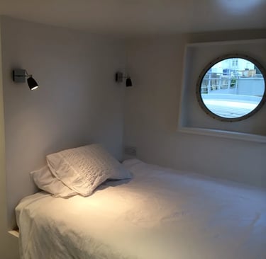 Een kamer op een woonboot met een patrijspoort