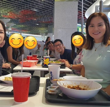 a group of japanese people sitting at a table with smiley faces