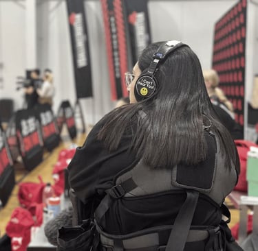 a woman in a black jacket and headphones on a basketball court