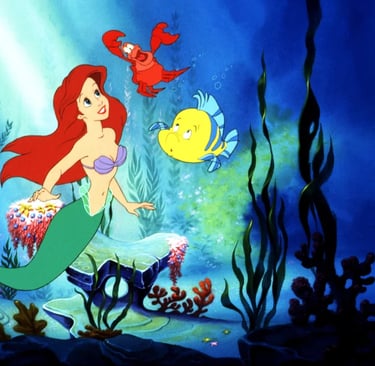 Ariel swims underwater with sea creatures in Disney’s The Little Mermaid (1989)