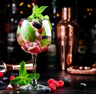a glass of wine with berries and mint leaves de Lu Mezcal