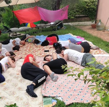 a group of people sitting on a blanket on a blanket, rilassamento, classe bioenergetica