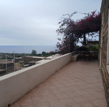 Panoramic terrace of dammuso in Rekhale with flowering pergola and sea view