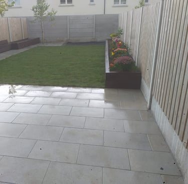 The after picture of the backyard patio with a large lawn