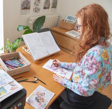 a woman sitting at a desk drawing