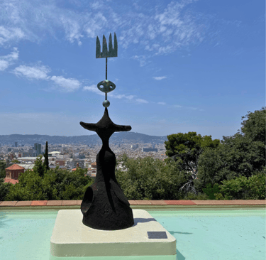 a sculpture of a woman in a black dress with Barcelona view on the background