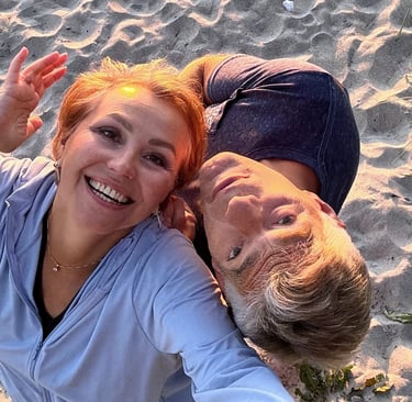Smiling couple enjoying sunset on the beach, radiating joy, love, and playful connection.