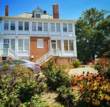 backyard of 2123 Rivermont apartments showing flowers in the foreground and house in background