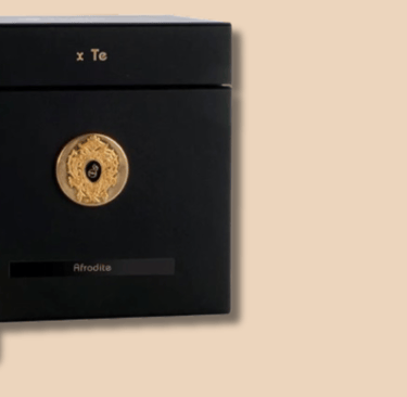 a bottle of perfume with a black box and a gold medal