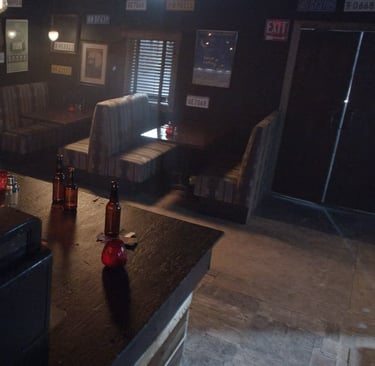 Bar room set at Grayfox Studios with counter, bottles, booths, and vintage wall decor
