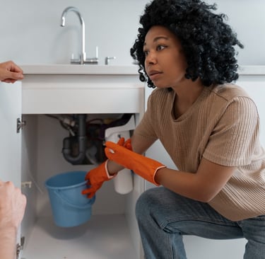 a man and woman in a kitchen with a sink