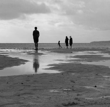 People walking along a Mauritian beach at low tide, Cape Town Photography Festival 2025.