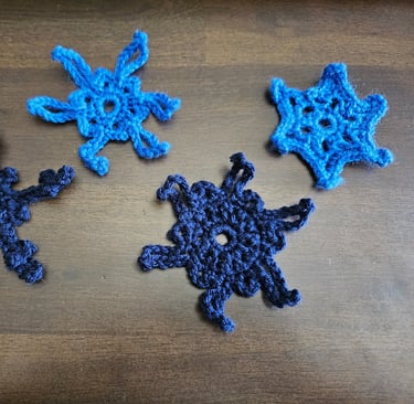 blue crochet snowflakes on a wooden table
