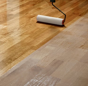 Brand new hardwood flooring is being finished with a roller. Showing raw and finished hardwood.
