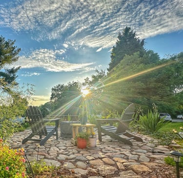 a patio with chairs and a fire pit