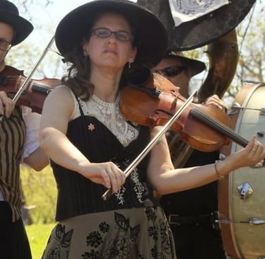 Band member playing violin during a live performance with Mazel Tov Kocktail Hour