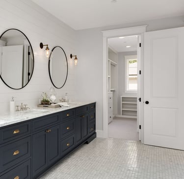 Duża łazienka z dwoma lustrami i dwoma umywalkami zatopionymi w kamiennym blacie