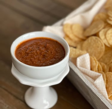 "Do the Dance" Hot salsa in a bowl beside a container with tortilla chips