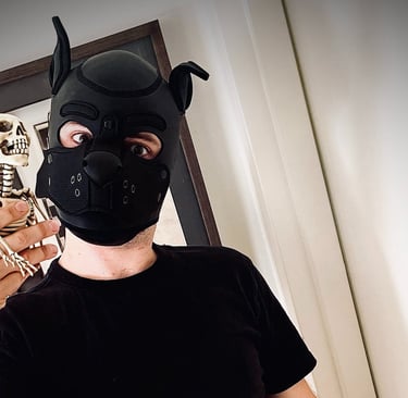 Man posing in a pup mask with a toy skeleton.