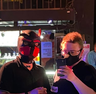 2 men in pup masks standing in a club.