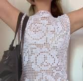 a woman in a white crochet top and black pants