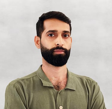 Portrait of VISUALISE founder in green shirt, light gray background.