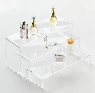 Acrylic risers displaying elegant perfumes and delicate jewelry, enhancing item visibility and decor