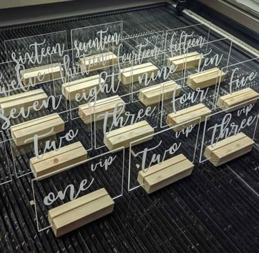 Clear acrylic table numbers with elegant white script numbering from 'one' to 'fifteen,' Rectangular