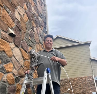 After a King Organic Dryer vent cleaning man standing on ladder holds large pile of lint