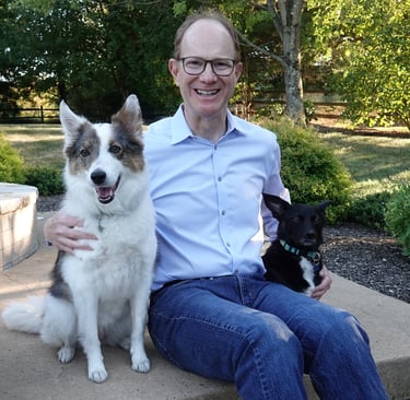 Photo of Michael Rabinowitz with his two dogs in backyard