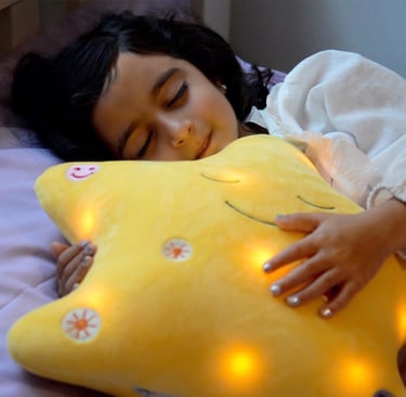 Little girl sleeping, holding her My Dua' star pillow by Desi Doll