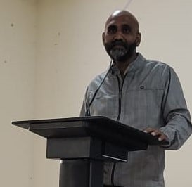a man standing at a podium with a microphone