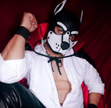 A man poses wearing a vampire cape and a pup mask.