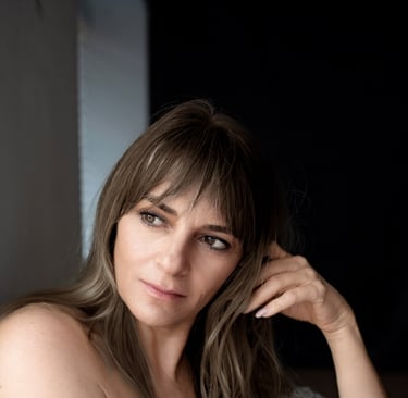 a woman in a blue dress sitting on a bed