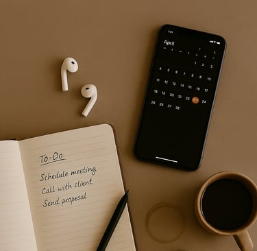to-do list notebook, smartphone showing a calendar, coffee mug, earbuds, and writing tools arranged