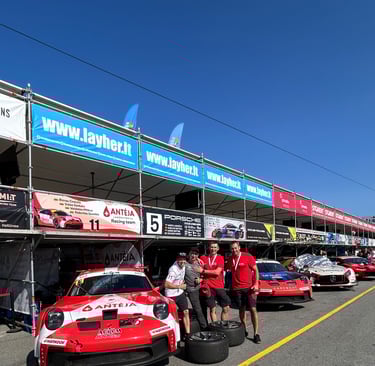 an Enlab group of people standing around a Porsche car in front of a building