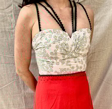 A strappy sundress with a green/white bodice and bright red skirt