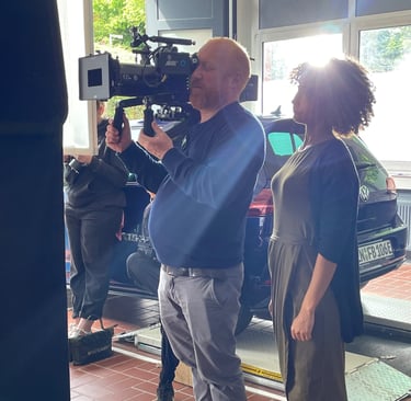 a man and woman standing in front of a camera