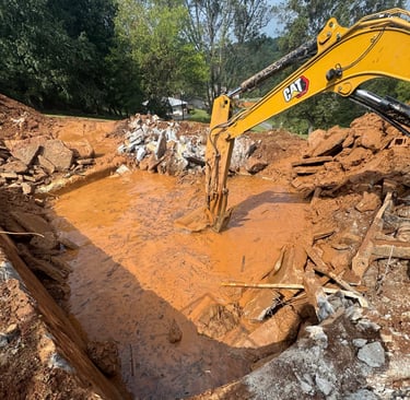 excavator digging out concrete pool