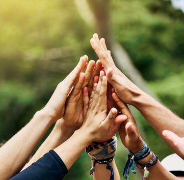 Group of people put their hands together in celebration