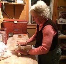 a woman in a red sweater and jeans, cooking