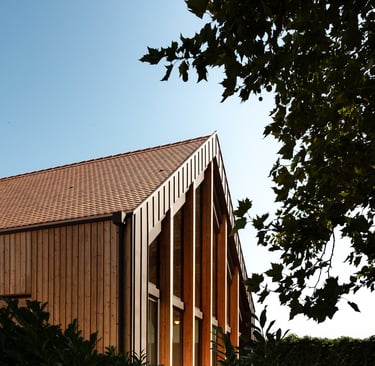 a building with a clock towering over a hedge