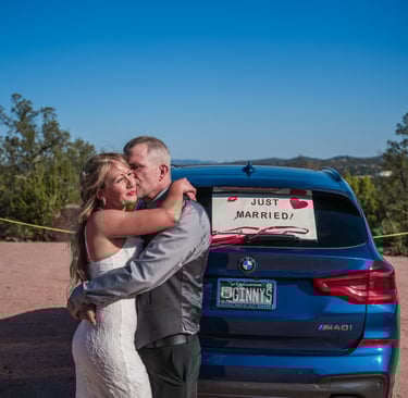 a man and woman standing in front of a car
