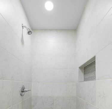 Image of tiled walk-in shower with recessed shelf and spotlight