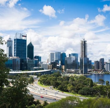 City skyline with river and greenery in foreground