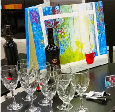 a table with wine glasses and canvas painting