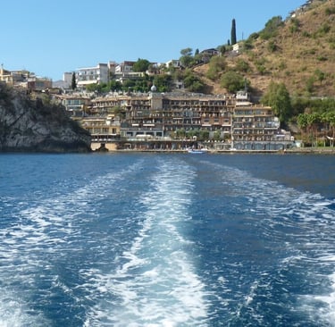 a boat traveling down the water with a view of a city