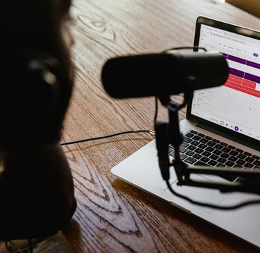 Microphone on a table and a laptop with a radio automation system open