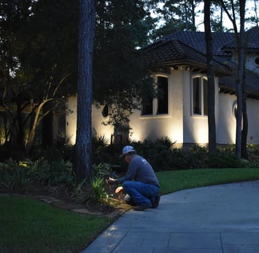 a man kneeling down to a tree in front of a house